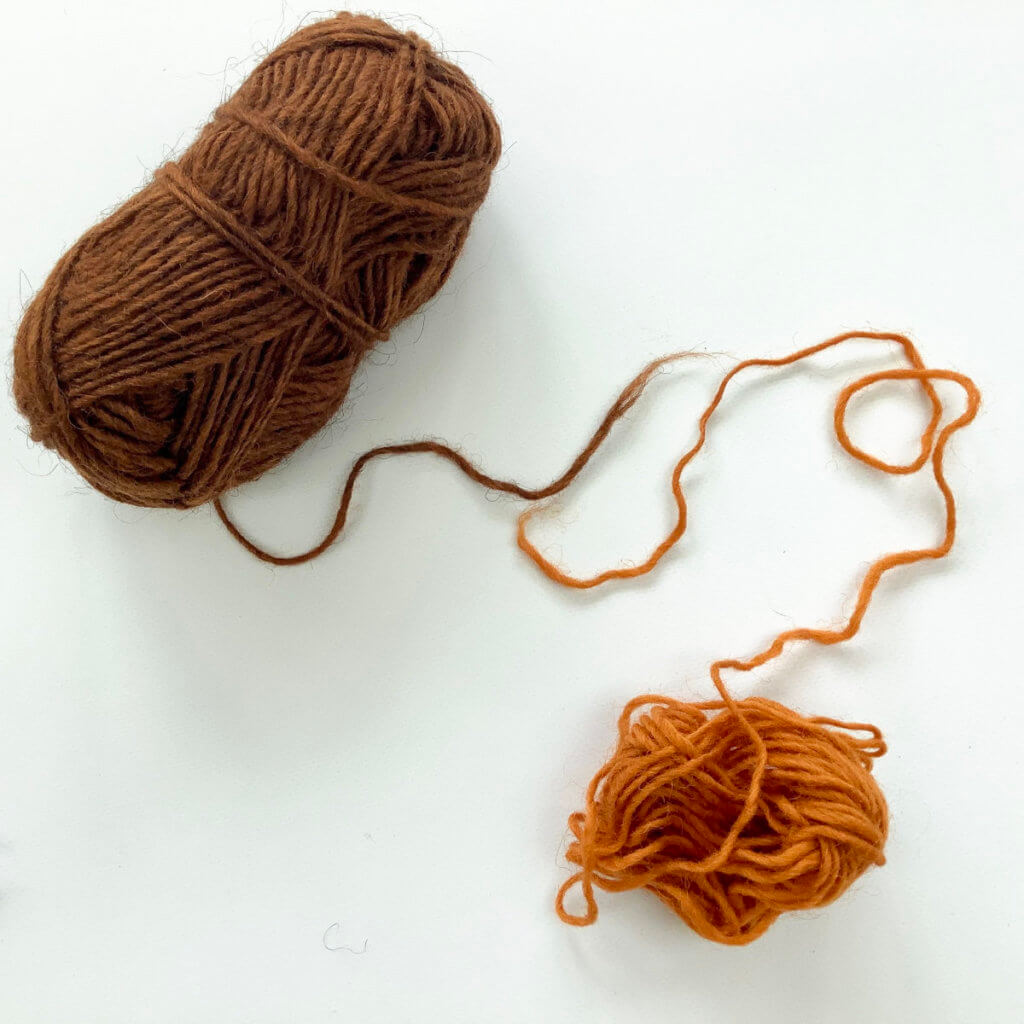 2 balls of yarn, 1 brown, and 1 orange