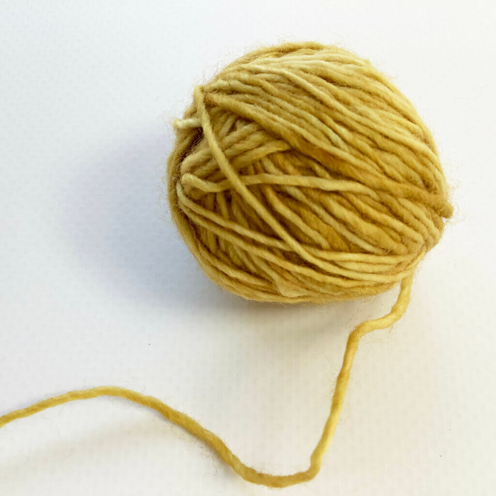 A ball of yellow fingering weight yarn