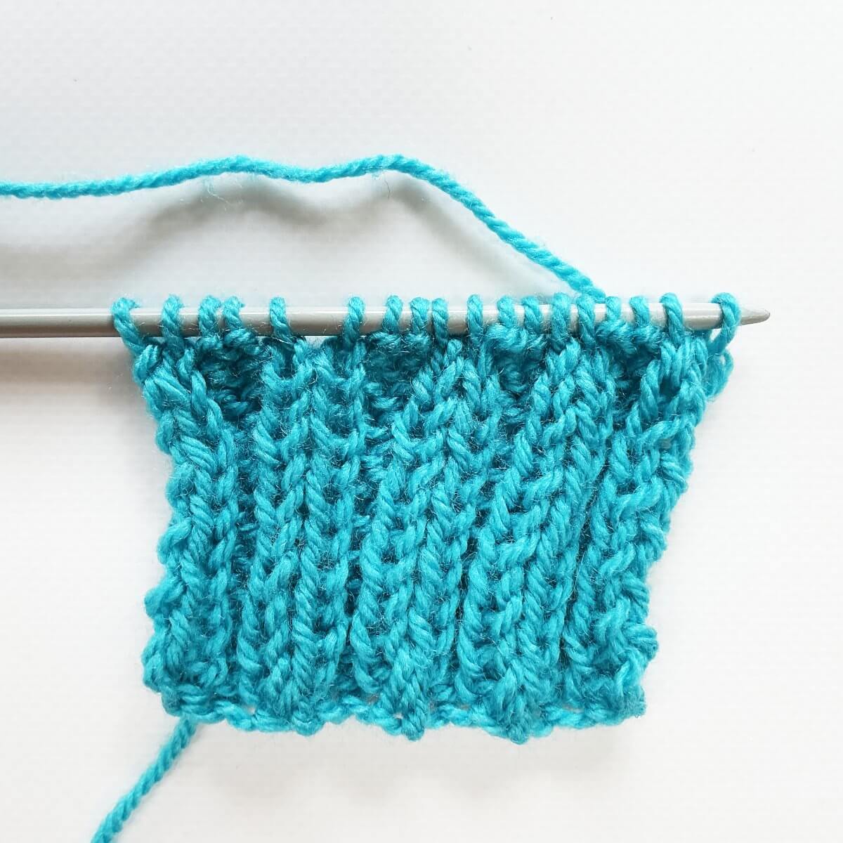 Working the stretchy YO bind-off for 2x2 rib, step 1