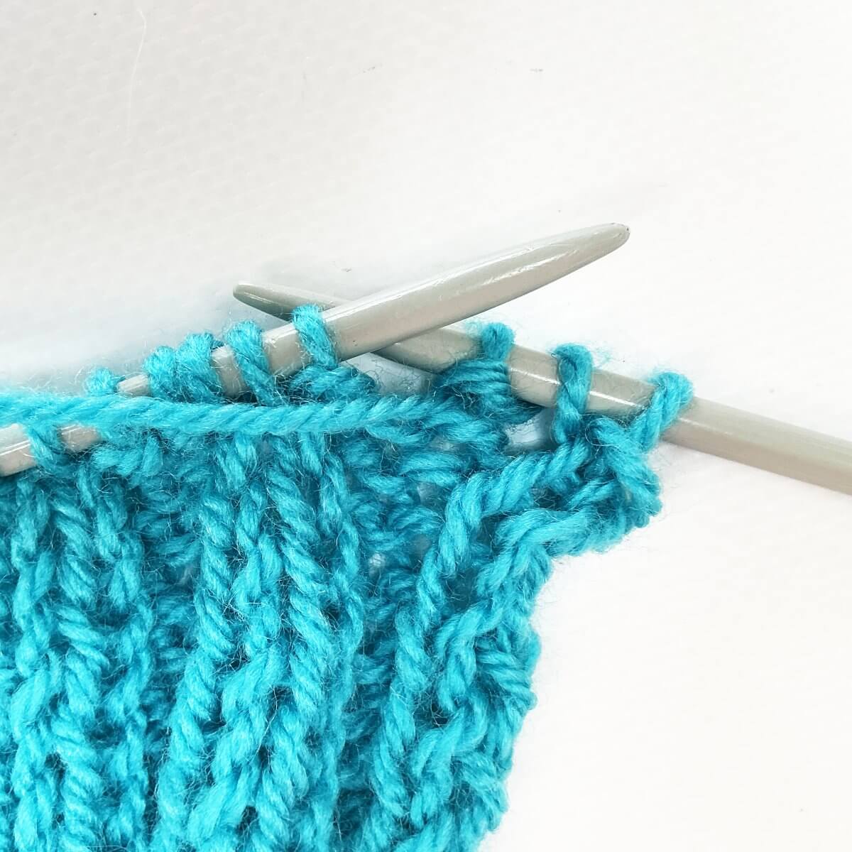 Working the stretchy YO bind-off for 2x2 rib, step 7