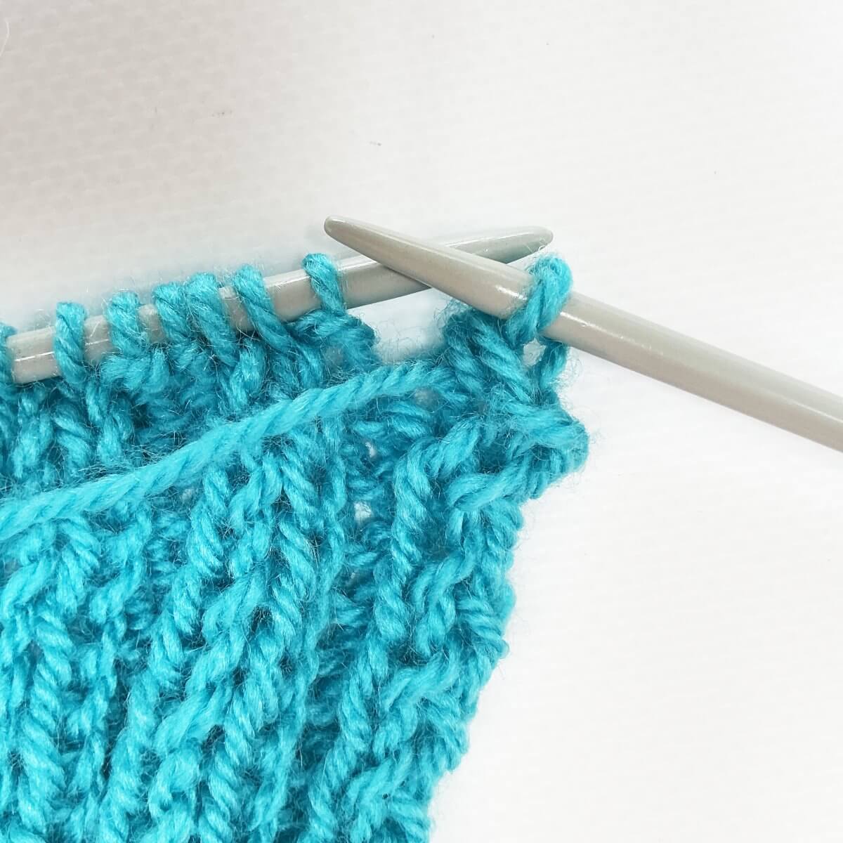 Working the stretchy YO bind-off for 2x2 rib, step 9