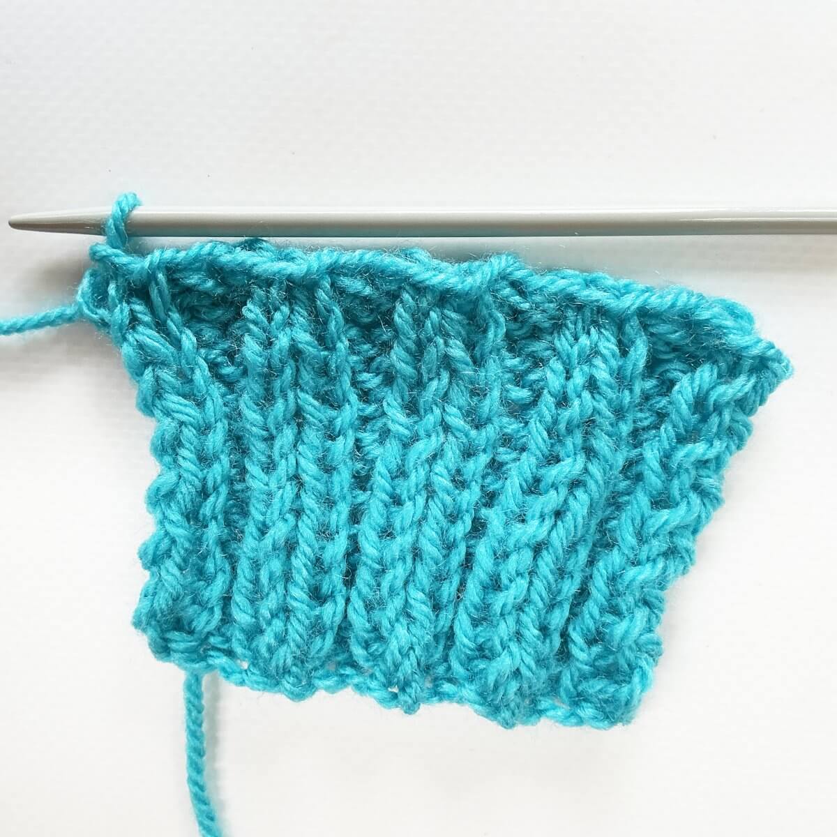 Working the stretchy YO bind-off for 2x2 rib, the result