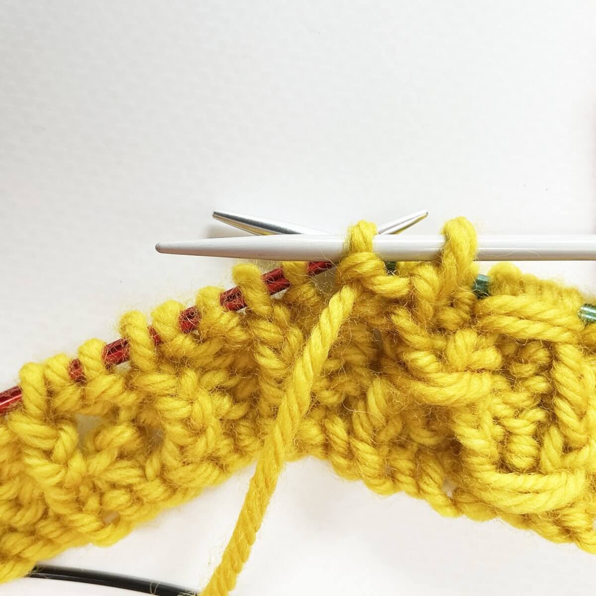 Step 3 of working the (k tbl, p2, k tbl) wrapped twice stitch