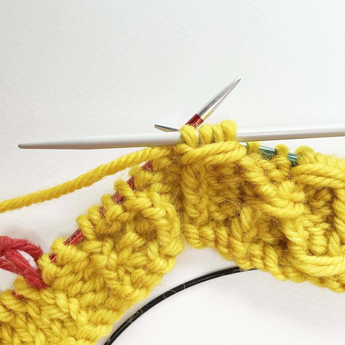 Step 7 of working the (k tbl, p2, k tbl) wrapped twice stitch
