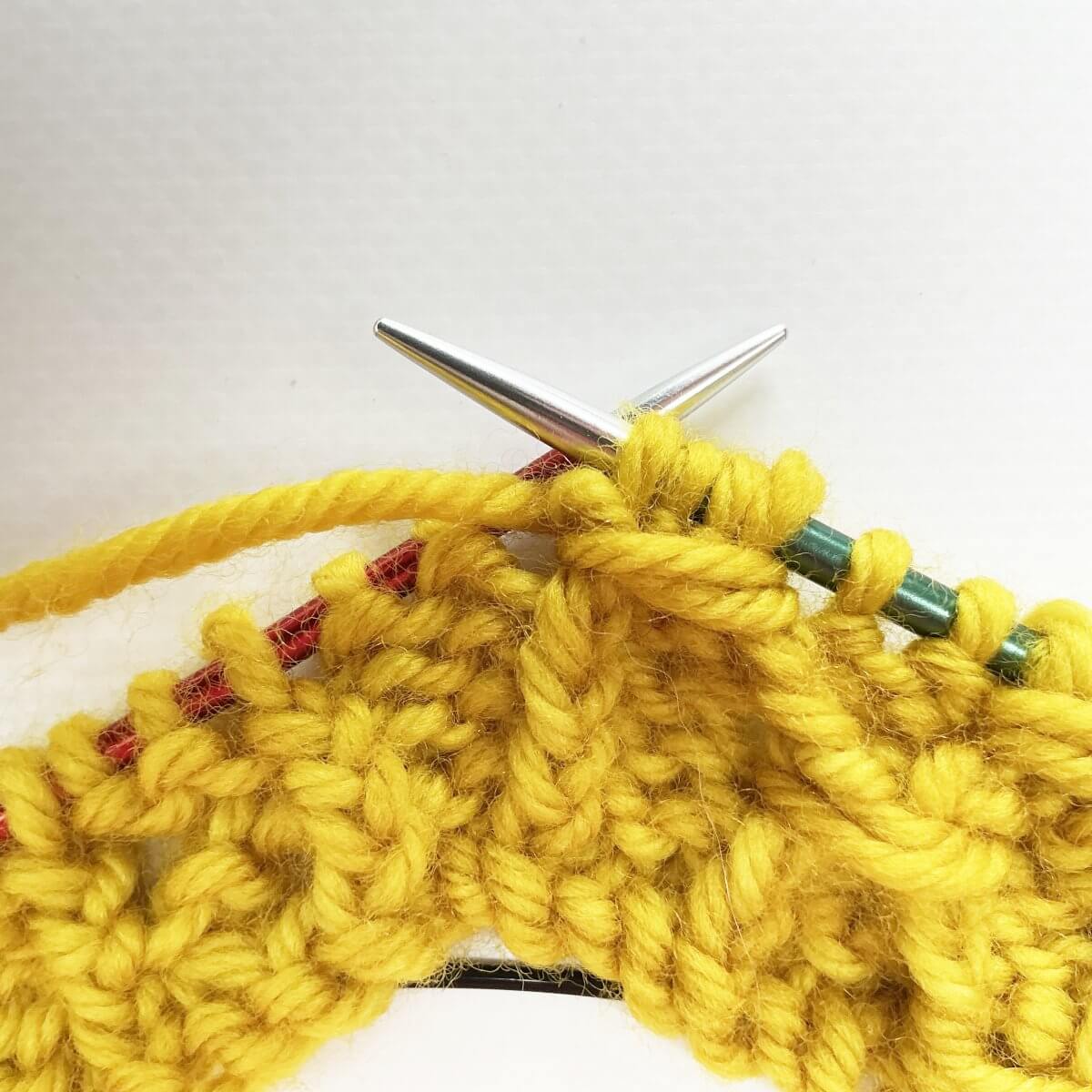 Step 8 of working the (k tbl, p2, k tbl) wrapped twice stitch