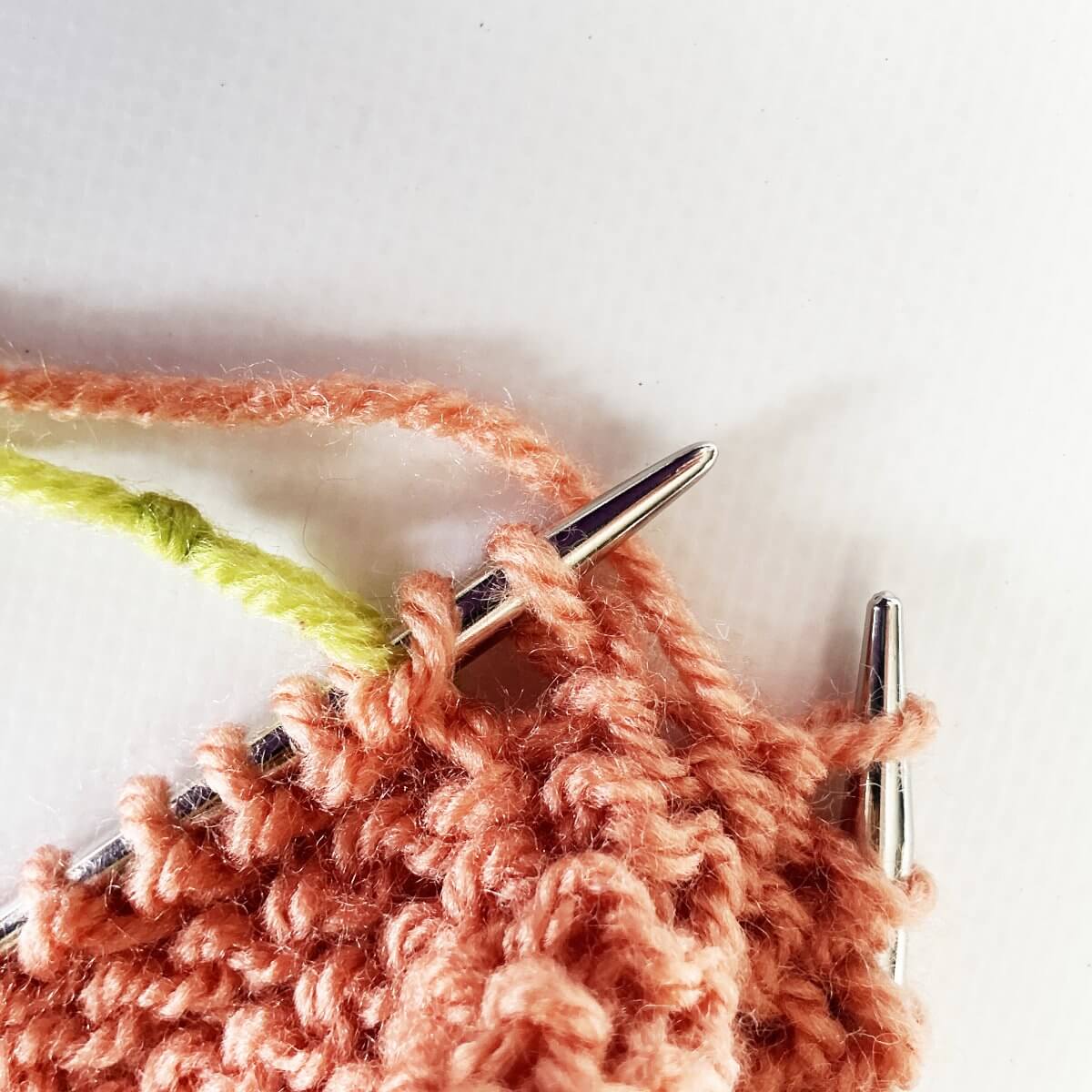 Step 5 of working jog-less garter stitch in the round with the lifted strand & p2tog method